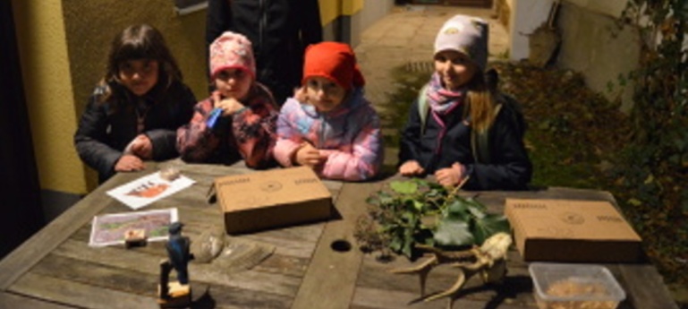 Děti u stolku s přírodninami.